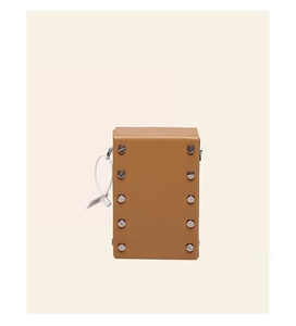Detailed shot of tan structured mini crossbody bag featuring silver screw stud accents