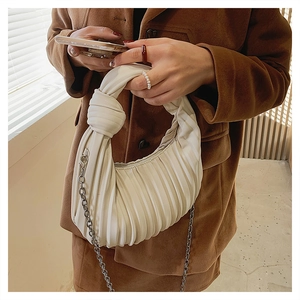 Détail du sac sous l'aisselle blanc plissé avec poignée nouée et chaîne argentée