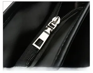 Detailed macro view of durable polished silver metal zipper head on black leather tote