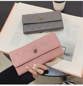 Detail of grey and pink quilted long wallets with golden flower buckles on a table