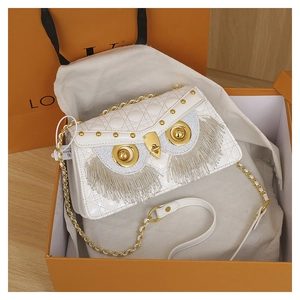 Macro shot of owl chain bag with quilted leather texture and pearl tassel details