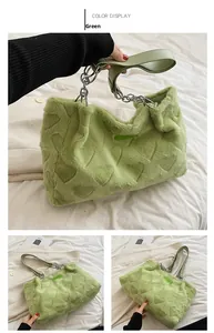Detail of green plush heart-embossed tote bag with silver chain handle and leather strap