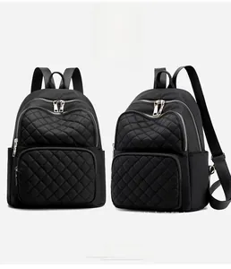 Detailed view of black nylon backpack featuring diamond quilted patterns and silver zippers