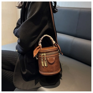 Vue détaillée d'un sac seau vintage marron avec poignée ornée d'un foulard imprimé léopard