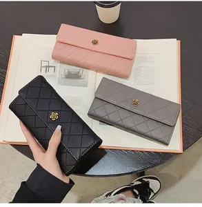 Detailed view of quilted long wallets in pink, black, and gray with floral metal buckle