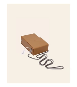 Detail of a brown leather box bag with a silver snake chain and minimalist flap closure