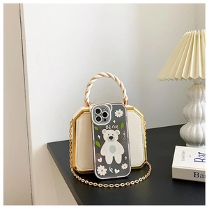 Detail of transparent phone case with bear and daisy prints next to a white chain bag