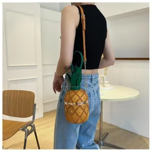 Détail d'un sac seau créatif en forme d'ananas avec rivets dorés et feuilles en cuir