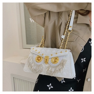 Detail of owl crossbody bag featuring silver fringe eyes and quilted leather texture
