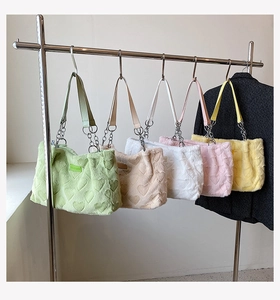 Close-up of fluffy heart-embossed tote bags with leather chain straps in various colors