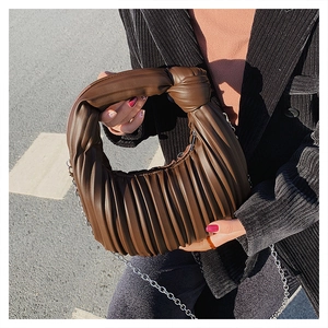 Détail du sac plissé en cuir marron foncé avec poignée nouée et chaîne en métal argenté