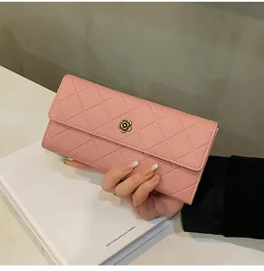 Detail view of pink quilted long wallet with golden flower clasp and embroidery