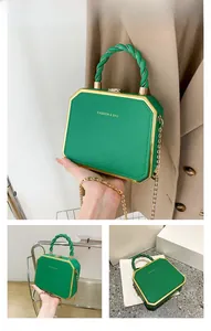 Detail view of green octagonal box bag with fashion letter print and gold chain strap