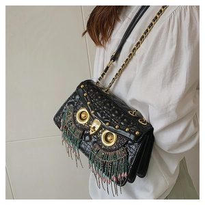 Detail of owl-shaped quilted crossbody bag featuring vibrant colorful bead tassels and gold chain