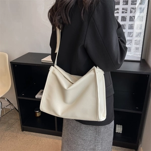Large capacity white commuter shoulder bag with pebble texture shown on model