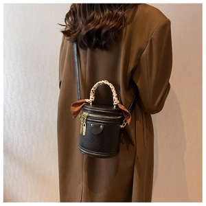 Détail d'un sac seau noir avec poignée en foulard léopard et breloque cadenas doré