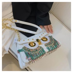 Close-up of white quilted owl crossbody bag with colorful bead tassels and gold chain