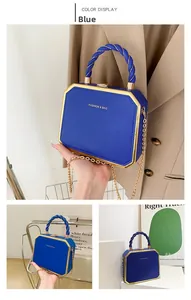 Detail of blue octagonal hard shell handbag with golden chain and textured leather