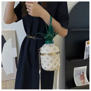 Détail du sac seau ananas blanc avec rivets dorés et poignée en feuilles vertes