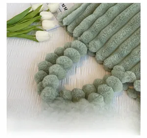 Détail du sac cabas en peluche vert sauge avec anse à pompons et texture rayée