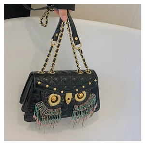 Detail of owl-shaped quilted crossbody bag with metallic eyes and colorful beaded fringe