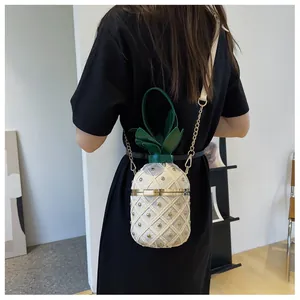 Détail du sac seau ananas créatif avec tissu matelassé, rivets dorés et décor de feuilles