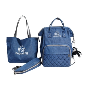 Three-piece denim blue mummy bag set including diaper backpack, tote bag, and storage pouch