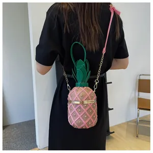 Détail du sac seau ananas rose avec clous dorés et bandoulière en chaîne métal