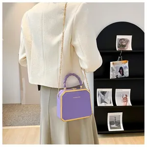 Close-up of a purple octagonal chain box bag with gold metal frame and fashion text