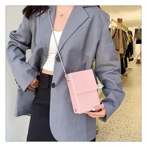 Detailed shot of pink mini crossbody bag with silver chain strap on female model