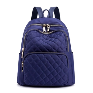 Navy blue nylon quilted backpack with gold zippers and spacious compartments for travel