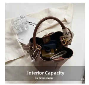 Internal capacity of brown leather bucket bag with wide strap showing daily essentials
