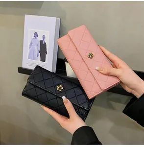 Close-up of long quilted wallet with elegant metal flower clasp in pink and black
