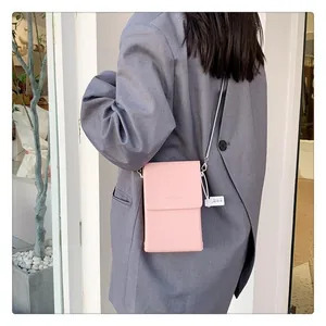 Detail of pink mini crossbody bag showing textured leather and elegant gold logo