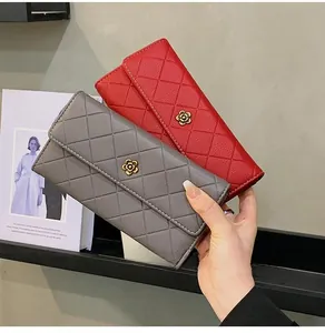 Close-up of red and grey quilted wallets with camellia metal buckles and pebbled texture