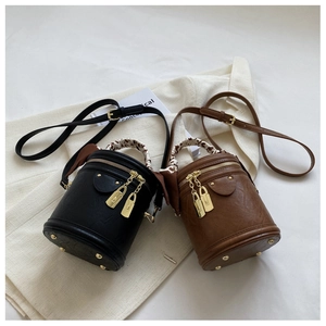 Détail de sacs seaux tendance noir et marron avec anses en foulard imprimé léopard
