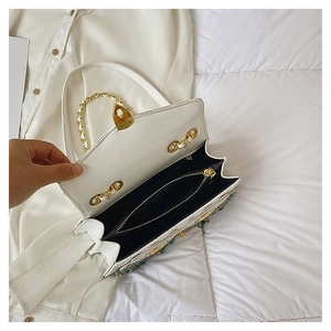 Detail view of the white crossbody bag's interior compartments and colorful beadwork