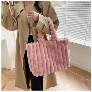 Détail du sac cabas en fausse fourrure rose avec poignée en boules de peluche douce