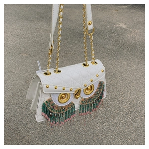 Detail of owl-shaped crossbody bag with colorful bead fringe and quilted white leather
