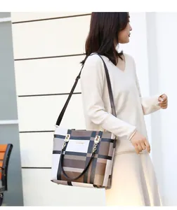 Classic checkered tote bag worn as a crossbody bag with adjustable brown strap