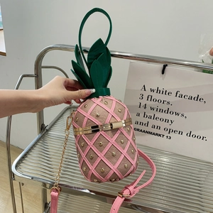 Sac bandoulière rose en forme d'ananas avec rivets dorés et détails de feuilles