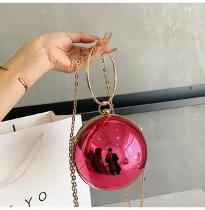 Macro view of spherical pink metallic acrylic evening bag with gold ring handle and chain