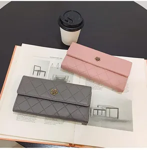 Detail of pink and grey long wallets with diamond quilting and rose gold flower clasp