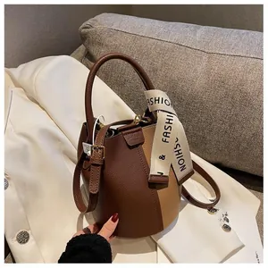 Detailed shot of brown bucket bag with lychee grain leather and fashion printed strap