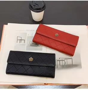 Close-up of long flap wallets in red and black with quilted texture and camellia ornament