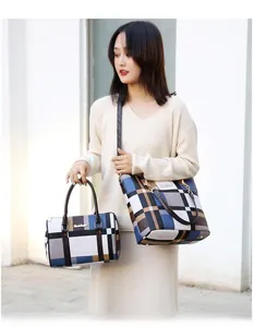 Outdoor street style view of large plaid tote bag and handbag set on pavement