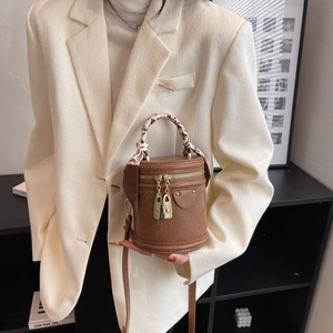 Sac seau rétro marron avec foulard léopard, porté sur un tailleur blanc élégant