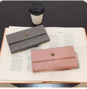 Detailed close-up of grey and pink quilted wallets with floral metal buckles on a magazine