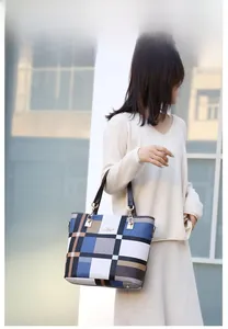 Detail of color-block plaid tote bag with gold chain hardware and slim brown handles