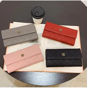 Detailed flat lay of quilted long wallets in grey, red, pink, and black with floral metal clasp
